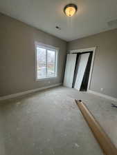 Unfurnished bedroom featuring visible vents, a closet, baseboards, and a textured ceiling