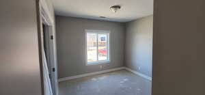 Spare room with concrete flooring, baseboards, and visible vents