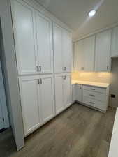 Kitchen with light countertops, white cabinets, recessed lighting, and dark wood finished floors