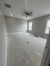 Unfurnished room featuring baseboards, visible vents, a textured ceiling, and a ceiling fan