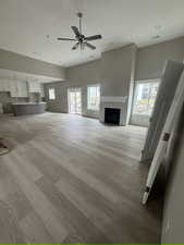 Unfurnished living room featuring a fireplace, wood finished floors, and a healthy amount of sunlight