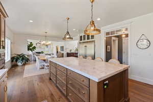 Kitchen featuring built in refrigerator, plenty of natural light, dark wood-type flooring, and a center island