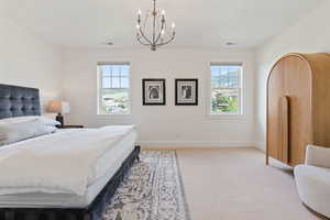 Bedroom with light carpet, baseboards, and visible vents