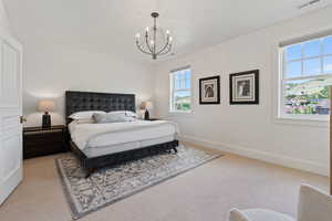 Bedroom featuring light carpet, baseboards, visible vents, and an inviting chandelier