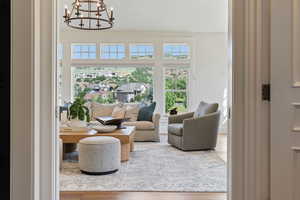 Living area with wood finished floors and an inviting chandelier