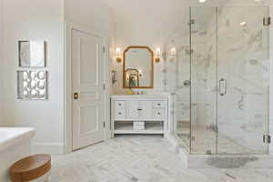 Full bathroom with vanity, a stall shower, and baseboards