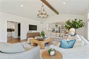 Living area with lofted ceiling with beams, visible vents, a chandelier, wood finished floors, and recessed lighting