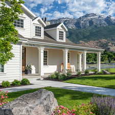 View of front of house with a front yard, a porch, a mountain view, and a chimney