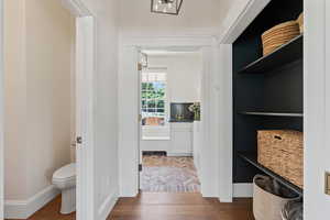 Bathroom featuring toilet, baseboards, and wood finished floors