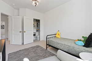 Carpeted bedroom with baseboards and a closet