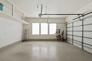 Garage featuring baseboards and a garage door opener