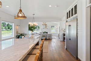 Dining area with a textured ceiling, an inviting chandelier, recessed lighting, and wood-type flooring