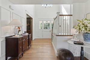 Foyer entrance with light wood-style flooring and a chandelier