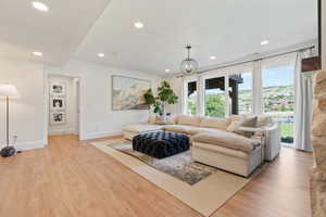 Living room featuring a textured ceiling, recessed lighting, and light wood-type flooring