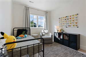 Bedroom featuring baseboards, carpet flooring, and visible vents