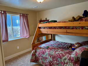 Bedroom featuring baseboards, visible vents, and carpet