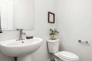 Bathroom featuring baseboards, a sink, and toilet