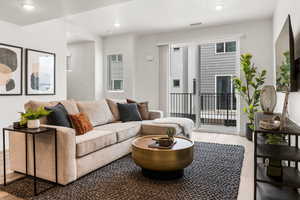 Living area featuring wood finished floors, recessed lighting, and visible vents
