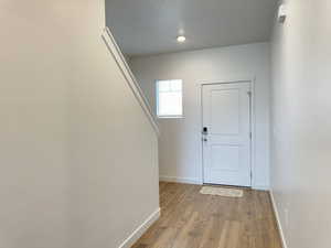 Entrance foyer featuring baseboards and light wood-style flooring