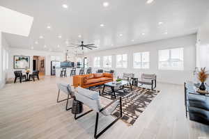 Living area with light wood-type flooring, baseboards, ceiling fan, and recessed lighting