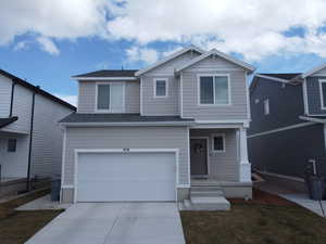 Craftsman inspired home featuring an attached garage, a front yard, concrete driveway, and roof with shingles