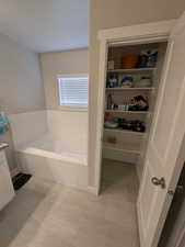 Full bathroom featuring a bath and baseboards