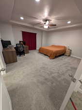Carpeted master bedroom with baseboards, a textured ceiling, recessed lighting, and a raised ceiling
