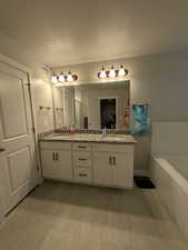Bathroom featuring double vanity, a sink, a garden tub, and wood finished floors