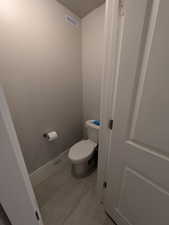 Bathroom with baseboards, visible vents, and toilet