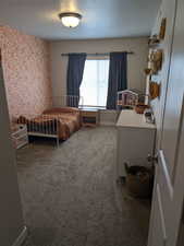 Carpeted bedroom with a textured ceiling (bedroom 2)