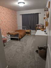 Carpeted bedroom featuring a textured ceiling (Bedroom 2)