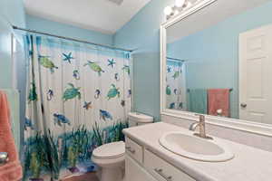 Full bath with toilet, vanity, and a shower with curtain