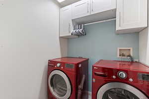 Clothes washing area featuring cabinet space and independent washer and dryer