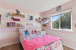 Bedroom featuring baseboards and wood finished floors