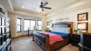Carpeted bedroom featuring recessed lighting, baseboards, a textured ceiling, a raised ceiling, and a ceiling fan