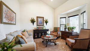 Living area with vaulted ceiling and carpet floors