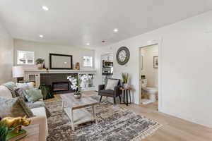 Living room with light wood-style flooring, baseboards, a healthy amount of sunlight, and recessed lighting