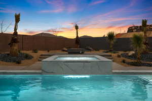 View of pool with a fenced in pool, a fenced backyard, and an in ground hot tub