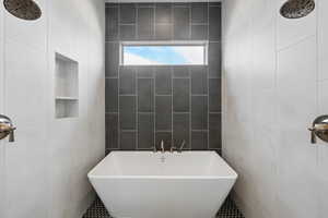 Full bath featuring tile walls and a freestanding bath