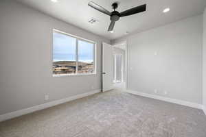 Carpeted spare room featuring baseboards, visible vents, ceiling fan, and recessed lighting