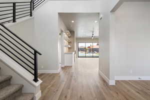 Entryway featuring baseboards, recessed lighting, light wood-style flooring, and stairway