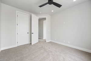 Unfurnished bedroom featuring light carpet, baseboards, recessed lighting, and a ceiling fan