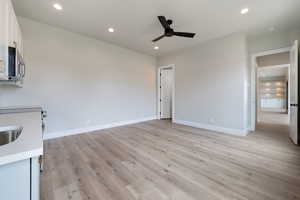 Interior space featuring white cabinetry, ceiling fan, stainless steel microwave, and recessed lighting