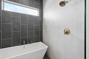 Bathroom with a soaking tub and a tile shower
