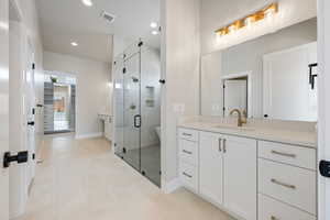 Bathroom with visible vents, a stall shower, recessed lighting, and vanity