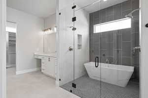 Full bathroom with vanity, baseboards, a soaking tub, tile patterned floors, and a stall shower