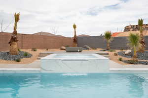View of pool featuring a fenced in pool, a fenced backyard, and an in ground hot tub