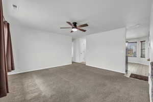 Carpeted spare room with baseboards, ceiling fan, and visible vents