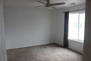 Carpeted empty room with baseboards, ceiling fan, and visible vents