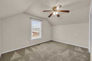 Bonus room featuring carpet flooring, visible vents, baseboards, ceiling fan, and vaulted ceiling